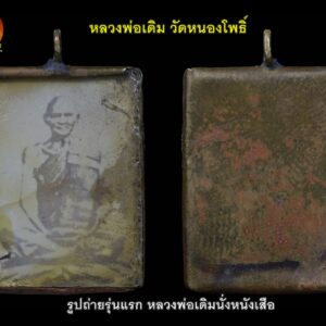 ตามประวัติหลวงพ่อเดิมท่านสั่งให้ทำขึ้นเพื่อแจกลูกศิษย์ ที่มาร่วมงานฉลองสมณศักดิ์ (ที่ พระครูนิวาสธรรมขันธ์ ในปีพ.ศ.๒๔๕๗ ) รูปนี้เป็นรูปแรกของท่าน ที่ทำแจกศิษย์และถือเป็นวัตถุมงคลรุ่นแรก ของที่ท่าน ทำออกแจกอย่างเป็นทางการ นับเป็นวัตถุมงคลของหลวงพ่อเดิม อีกชิ้นหนึ่งที่ค่อนข้างจะหาชมได้ยาก เมื่อพูดถึงรูปถ่ายนั่งบนหนังเสือของหลวงพ่อเดิมแล้ว ก็ขอพูดถึงหนังเสือแผ่นที่หลวงพ่อนั่งถ่ายรูปนั้น ว่า มีความเป็นมาอย่างไร เรื่องมีอยู่ว่า... ที่ป่าทึบเขตติดต่อแดนพม่า มีเสือตัวหนึ่ง "ชื่อไอ้เฒ่า" เป็นเสือแก่ไม่ทำอันตรายใคร ถ้ามีคณะพรานเข้าไปล่าสัตว์ได้มา มันรู้ มันจะมาร้องคำรามอยู่ใกล้ๆ พวกพรานรู้กันดี จะแบ่งสัตว์ที่ยิงได้ให้มัน มันจะออกมากิน อิ่มแล้วมันก็ไป มันไม่ทำอันตรายคน ไอ้เฒ่ามันจับสัตว์มากินตามลำพังของมัน มันเป็นเสือที่ใหญ่มาก มันหากินในป่าทึบมาจนถึงโกรกพระ ชาวบ้านและพรานท้องถิ่นเห็นมัน ก็จะไม่มีใครทำอันตรายมัน พวกเขารู้ว่ามันไม่ทำร้ายคน เพียงแต่มันมาหากินตามประสาของมัน มันเป็นเสือจำศิล ไม่เข้ามาโขมยจับสัตว์ของชาวบ้านกินให้เดือดร้อน ท่านผู้เล่า ยังเล่าให้ฟังต่อไปอีกว่า วันหนึ่งมีพรานต่างถิ่นเข้ามาล่าสัตว์ พรานเหล่านั้นจะใช้วิธีนั่งห้างยิง จะด้วยเจตนาหรือบังเอิญไม่ทราบ ไอ้เสือเฒ่ามันเข้ามาเดินวนเวียนอยู่แถวนั้นพอดี พรานที่นั่งอยู่บนห้างเห็นเข้า จึงยิงไอ้เฒ่าถึงแก่ความตาย พอรุ่งเช้าจึงมาหามร่างของไอ้เฒ่าออกจากป่า มาเจอชาวบ้านและพรานท้องถิ่นก็จำไอ้เฒ่าได้ จึงบอกให้ฟังว่ามันเป็นเสือจำศีล ไม่ทำร้ายใคร ไม่น่ายิงมันเลยเป็นบาปแท้ๆ เมื่อได้ยินเช่นนั้นเหล่าพรานป่าที่ยิงไอ้เฒ่า ต่างสำนึกผิด จึงจัดการแล่หนังไอ้เฒ่าออกเป็นแผ่นตากแห้ง และเมื่อตากแห้งเรียบร้อยแล้ว จึงนำหนังไอ้เฒ่ามาถวายหลวงพ่อเดิม เพื่อให้ท่านได้รองนั่งทำวิปัสสนา เผื่อกุศลนั้นจะส่งผลไปถึงไอ้เฒ่าและพรานผู้สังหารไอ้เฒ่า ด้วยเหตุนี้เอง จึงเกิดภาพหลวงพ่อเดิมนั่งบนหนังเสือขึ้นมา และภาพนี้ถือเป็นวัตถุมงคลชุดแรก ของหลวงพ่อเดิม ที่ทำแจกอย่างเป็นทางการ